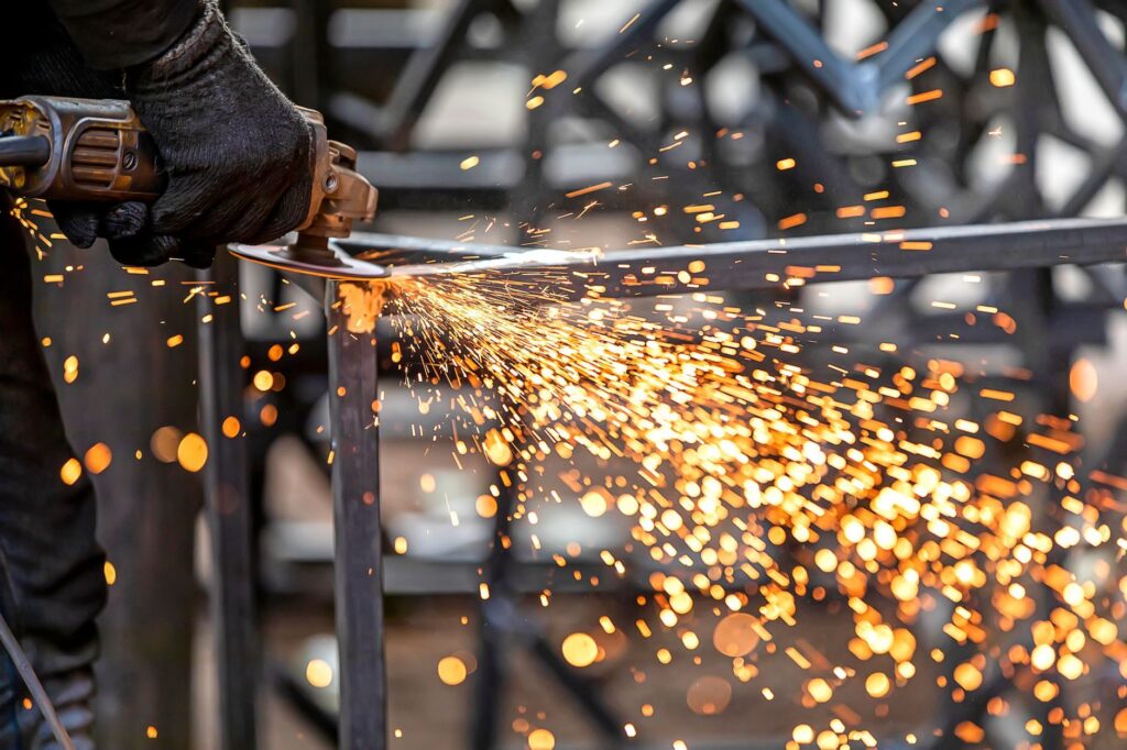 Photo d’illustration : découpe à la meuleuse d’un tube sur une structure en acier