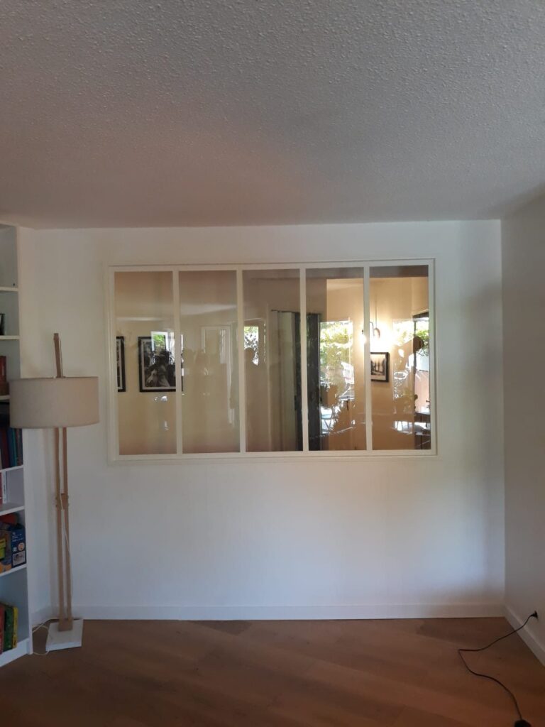 Verrière d’intérieur à cinq vitrages et cadre blanc, dans un salon